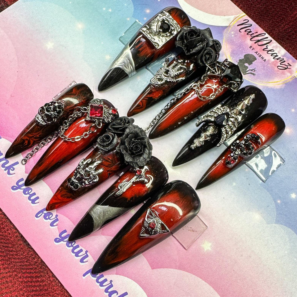 3D gothic press on nails with chrome details, skulls, roses, and chains on red and black marble base