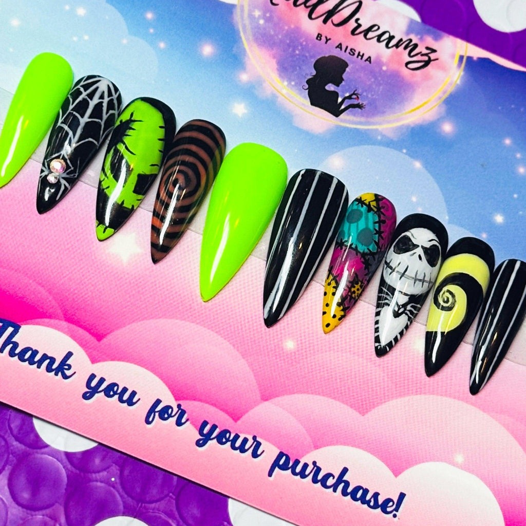 nightmare before christmas nail set on pink cloud backdrop with thank-you card; mix of neon green and black spooky art