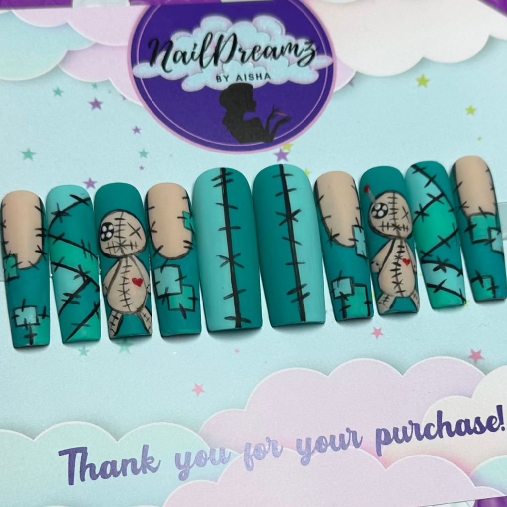 Full set of voodoo doll press on nails with stitched teal and nude patchwork, doll heart accent nail displayed on Nail Dreamz card.